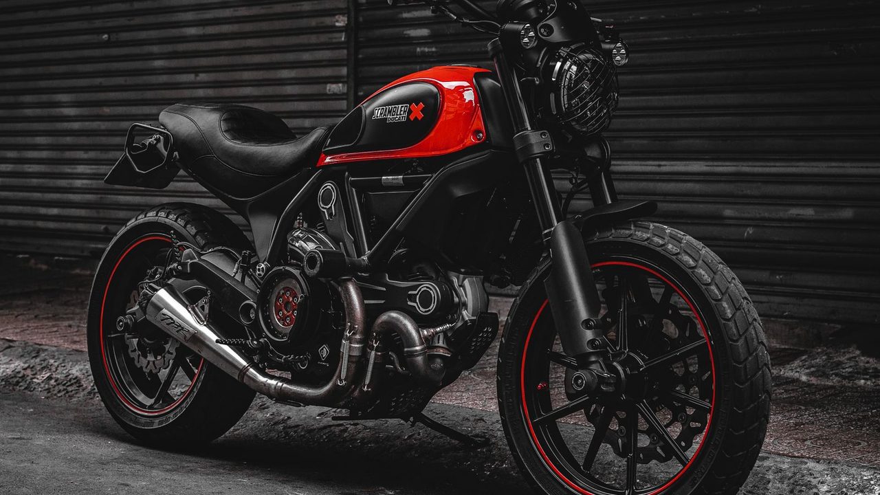 Candado de disco amarillo puesto en el freno delantero de una moto
