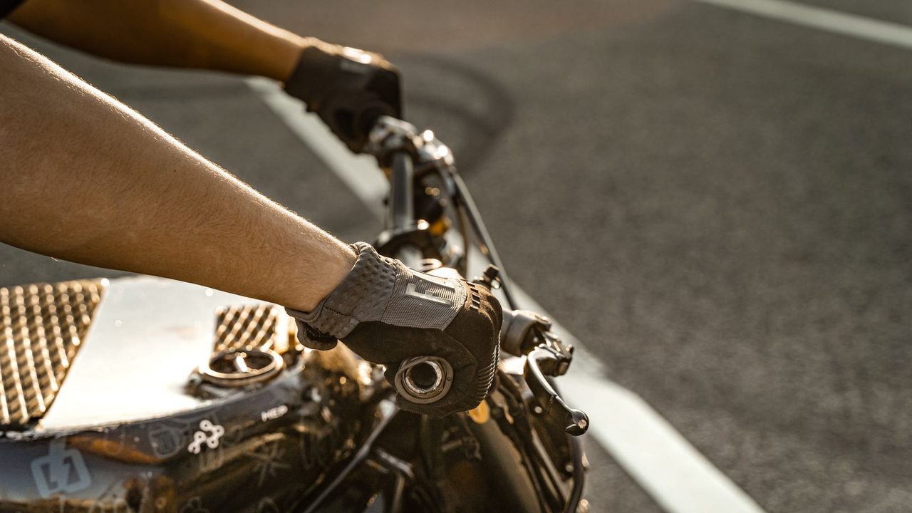 Manos con guantes de moto de cuero con protecciones sobre el manillar